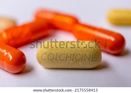 Colchicine tablet close up of medication used to treat gout and Behcet disease, pericarditis, familial mediterranean fever. Royalty-Free Stock Photo #2175558413