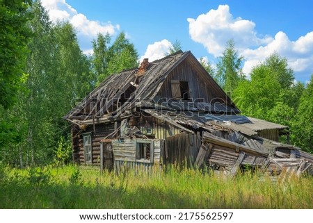 An abandoned wooden old house, desolation and ruin, an old village house among the trees In  fores Royalty-Free Stock Photo #2175562597