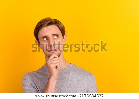 Photo of young uncertain guy hand touch chin think look empty space isolated over pastel color background
