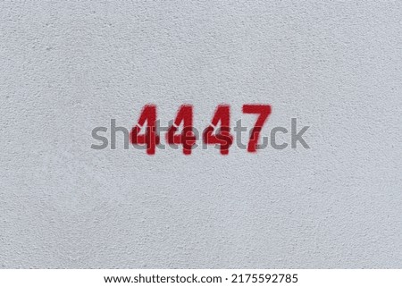 Red Number 4447 on the white wall. Spray paint.
