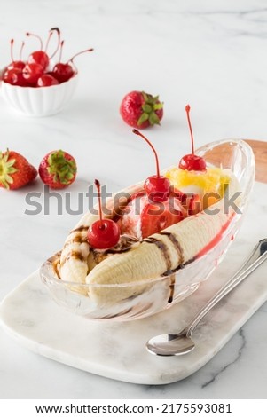 Banana split garnished with strawberries and maraschino cherries Royalty-Free Stock Photo #2175593081