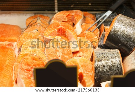 raw salmon steaks on metal box in shop 