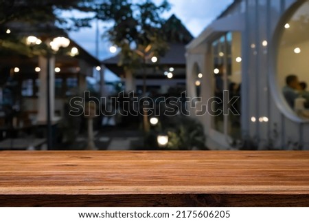 Empty wooden table space platform and blurred bar or bistro background for product display montage.