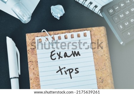 Exam tips text is shown on a piece of paper on study table.  Royalty-Free Stock Photo #2175639261