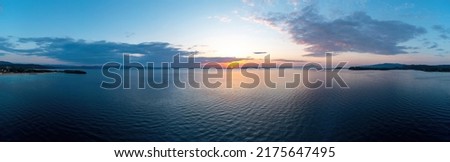 Sunrise over calm ocean aerial panoramic view. Dramatic sunset seascape in Aegean Sea. Orange and blue color shades cloudy sky. Chalkidiki, Greece Royalty-Free Stock Photo #2175647495
