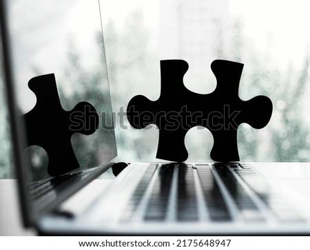 laptop with two pieces of puzzles icon on window frame background. jigsaw placed on desk. laptop computer in backdrop. Concept of effective management, business solutions and finding missing link Royalty-Free Stock Photo #2175648947
