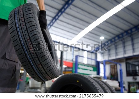 Car mechanic change tire In the process of bringing 4 new tires to a tire shop to replace motorcycle wheels at a service center or auto repair shop for the automotive industry