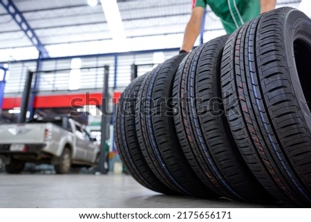 A tire changer is in the process of bringing new tires in stock and replacing them at a service center or auto repair shop for the automotive industry.