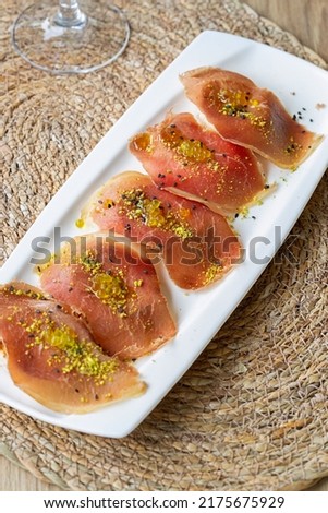 Cecina de Leon (Spanish Cured Beef Ham) with pistachio and extra virgin olive oil pearls on toasted bread Royalty-Free Stock Photo #2175675929
