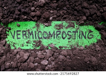 Vermicomposting organic farming concept. Written text word on soil background.	