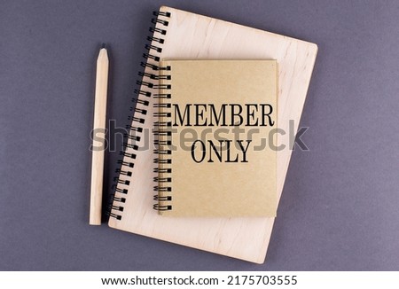 Word MEMBER ONLY on a notebook with pencil on the grey background