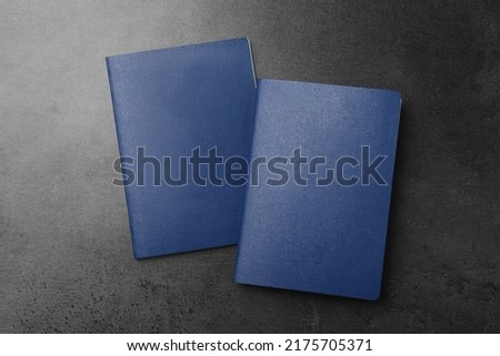 Blank blue passports on dark grey table, flat lay Royalty-Free Stock Photo #2175705371