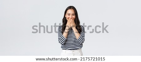 Lifestyle, people emotions and casual concept. Cute silly asian female giggle while gossiping and mocking someone, cover mouth as smiling and laughing carefree Royalty-Free Stock Photo #2175721015