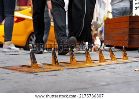 Close-up of yellow spikes for a tire puncture for stopping the car in a street of Istanbul Royalty-Free Stock Photo #2175736307