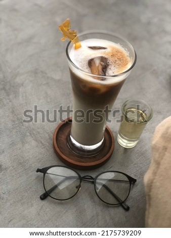 Unfocused Iced coffee milk with separate white sugar with glasses ready to be enjoyed during the day