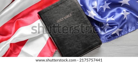 Holy Bible and USA flag on wooden background