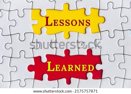 Lessons learned text on Jigsaw Puzzle with yellow and red background. Royalty-Free Stock Photo #2175757871