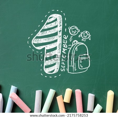 Pieces of colorful chalk and drawing on school blackboard, top view