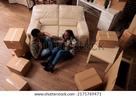 African american couple dreaming about apartment decor, moving in rented household flat and sitting together. Relocating in family house to start new beginnings, life event. Top view of.