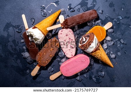 Set of various ice cream popsicle on black background. Assortment of icecream cones and popsicles on dark background top view flatlay copy space Royalty-Free Stock Photo #2175769727