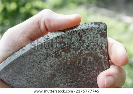 Blade sharpness check. Finger on the edge of a steel blade. Royalty-Free Stock Photo #2175777745