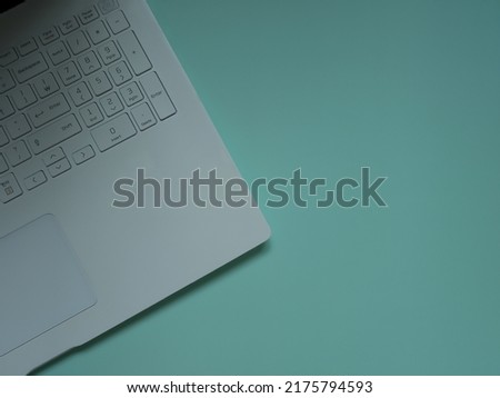 Laptop computer keyboard on turquoise background