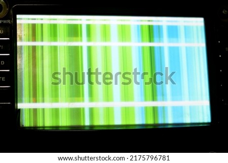 Broken LCD screen with multiple colors and pixelations with color errors and problems forming abstract color stripes background in white, green and blue colors, A car touch LCD TV, mp3 and DVD player