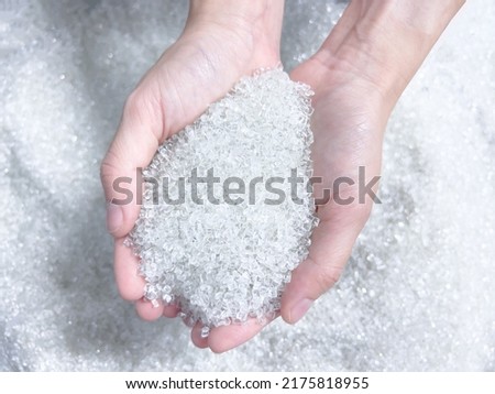 Woman hand holding Pet polyester chips,Plastic pet polyester chips,Chips bright.Chips formed by the melting of plastic scraps. Royalty-Free Stock Photo #2175818955