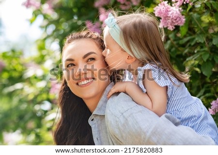 family, motherhood and people concept - happy mother with little daughter having fun at summer park or garden