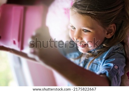 A little girl playing tablet lay on the bedroom