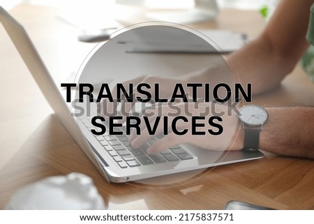 Translation services. Man working on laptop at table indoors, closeup