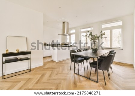 Home interior design of modern loft apartment with open kitchen in minimalist style and spacious dining zone with table and chairs Royalty-Free Stock Photo #2175848271