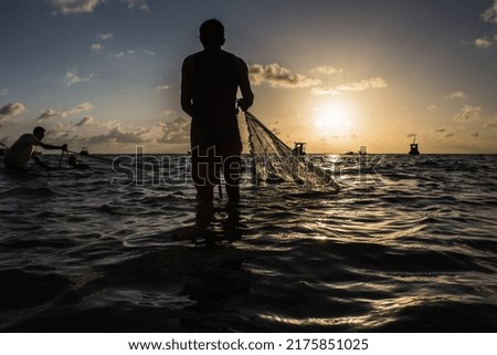 Manjuba fishing with fine net on the seashore. Royalty-Free Stock Photo #2175851025
