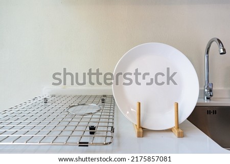Rack with clean dishes on minimal Royalty-Free Stock Photo #2175857081