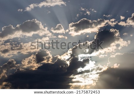 Shafts of sunlight poking through clouds in a beautiful southwestern monsoon season sky. A stunning cloudscape in the heavens with gorgeous beams and rays of light of the Sonoran Desert in Tucson, AZ.