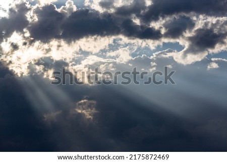 Shafts of sunlight poking through clouds in a beautiful southwestern monsoon season sky. A stunning cloudscape in the heavens with gorgeous beams and rays of light of the Sonoran Desert in Tucson, AZ.