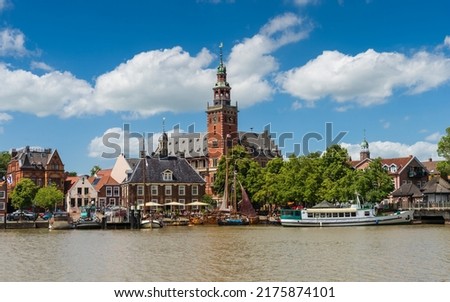 Leer, Germany. Panoramic view from Leda river on city hall, old weigh house in dutch classical baroque style, tourist harbor and bridge Royalty-Free Stock Photo #2175874101