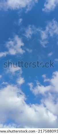 Beautiful white clouds on deep blue sky background. Elegant blue sky picture in daylight. Large bright soft fluffy clouds are cover the entire blue sky. Cumulus clouds in clear blue sky. No focus