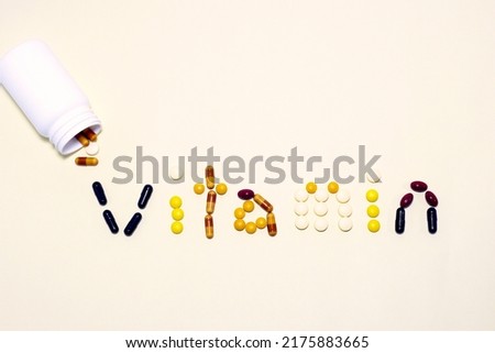Vitamins and supplements show "vitamin" word on vanilla color background. Including multi vitamins, vitamin B, vitamin C, vitamin D, collagen tablets, probiotics capsules and iron capsules. Royalty-Free Stock Photo #2175883665