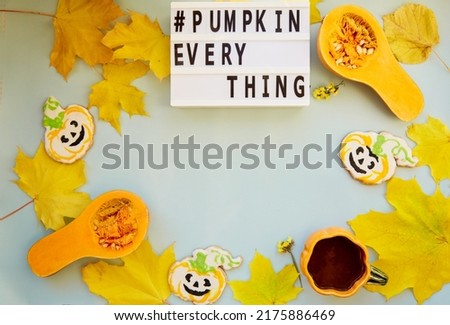 Text pumpkin everything among autumn decorations and food. Orange teacup with homemade cookies, fresh pumpkins, yellow leaves and chestnuts. Copy space. High quality photo