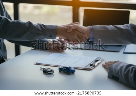 Close up of hands. Sale-man is selling and buying a car with loan agreement and financial between client.