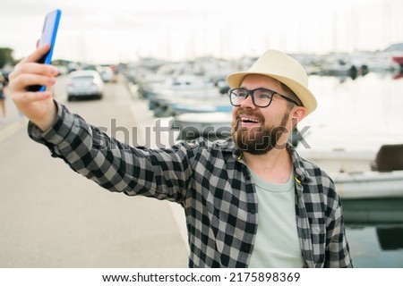 Traveller man taking selfie of luxury yachts marine during sunny day - travel and summer concept