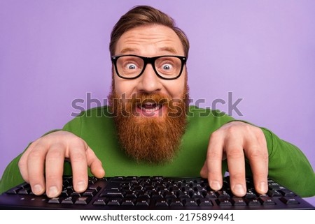 Portrait of young geek nerd in spectacles writing code making new html application isolated on violet color background