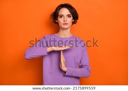 Photo of calm focused lady hands demonstrate timeout symbol isolated on orange color background