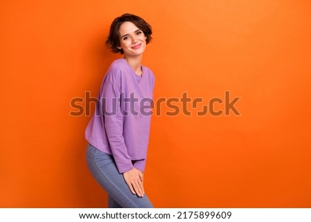 Photo of sweet charming lady wear violet sweatshirt smiling empty space isolated orange color background