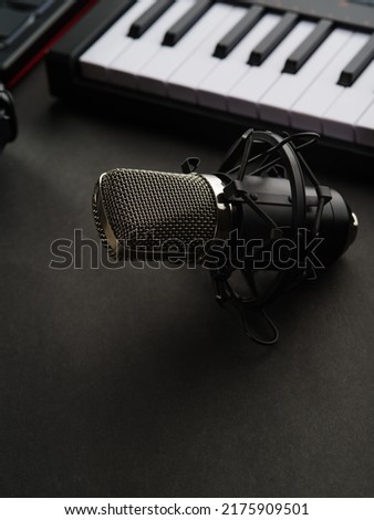 Studio microphone and synthesizer, midi keyboard on a gray background. Recording studio, vocal studio, workplace of a musician, composer, radio, television.