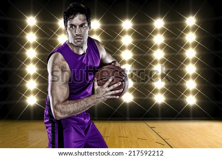 Basketball player on a  purple uniform, in front of lights.