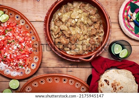 Chicharrones in green sauce, typical Mexican food. Meal served in a clay pot.