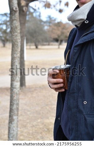 young boy dressed in blue jacket drinking argentine mates outdoors