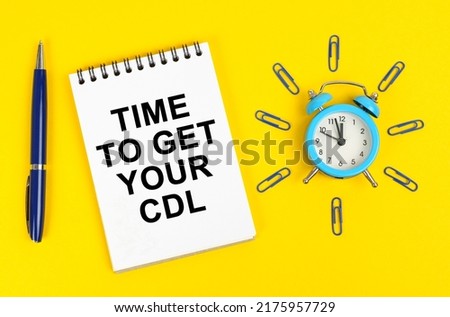 Business concept. On a yellow surface there is an alarm clock, a pen and a notepad with the inscription - Time to Get Your CDL Royalty-Free Stock Photo #2175957729